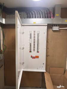 Distribution board with fitted front cover and cable containment above at the St Neots project