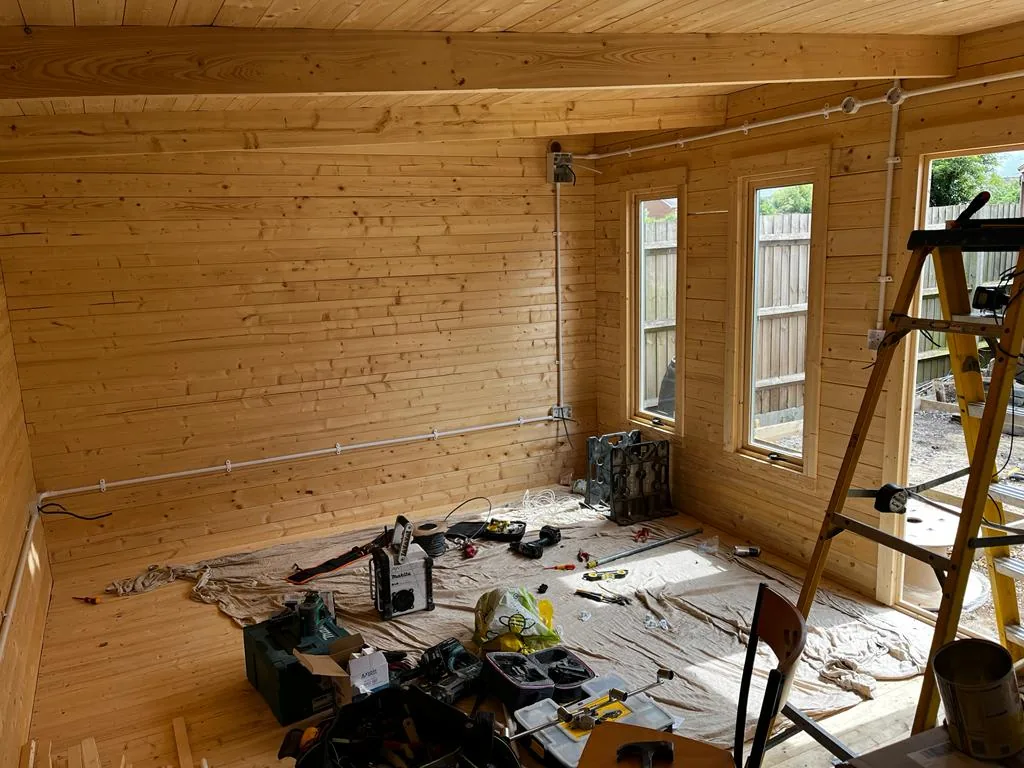 Electrical work in progress in a timber-lined room