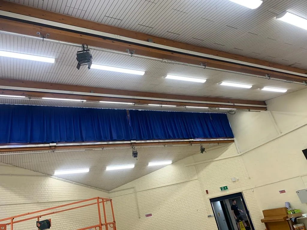 School hall lighting above the stage and seating area
